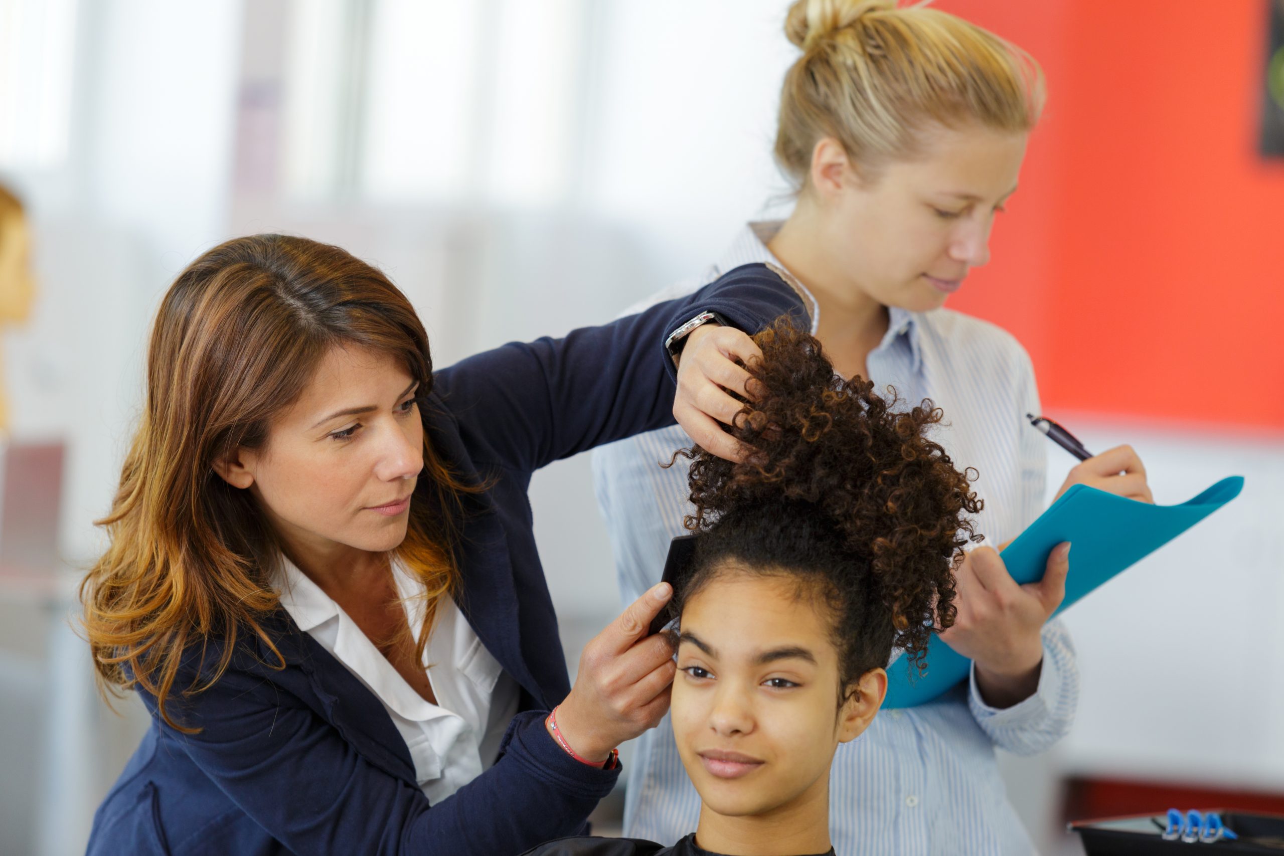 Cosmetology student taking notes from teacher